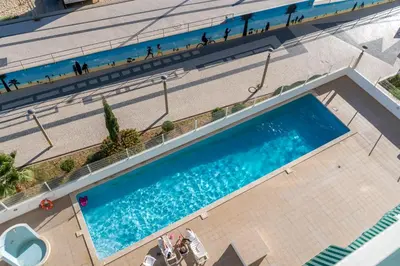 an overhead view of a swimming pool with people on the beach at Ocean Blue II in Quarteira