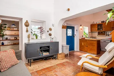 a living room with a tv and a kitchen at BeGuest Casa Romãzeira Typical Vila in Goncinha