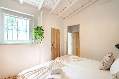 a white bedroom with a bed and a window at BeGuest Casa Romãzeira Typical Vila in Goncinha