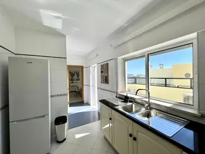 a kitchen with a sink and a refrigerator and a window at Faro Rising by Homing in Faro