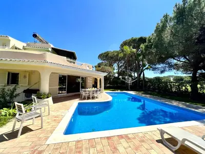 a swimming pool in front of a house at Vilamoura Amazing Golf Villa With Pool by Homing in Vilamoura