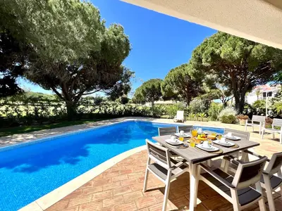 a patio with a table and chairs next to a swimming pool at Vilamoura Amazing Golf Villa With Pool by Homing in Vilamoura
