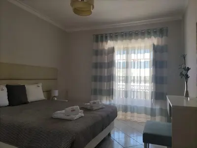 a bedroom with a bed with two towels on it at Bicos Beach Apartments By Albufeira Rental in Albufeira