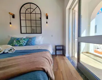 a bedroom with a bed and a large window at Vila Arvela in Albufeira