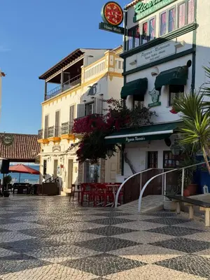 a building on a street with tables and chairs at The Best Downtown Albufeira in Albufeira