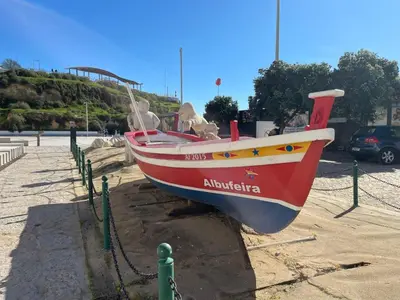 a boat sitting on the ground in a parking lot at The Best Downtown Albufeira in Albufeira
