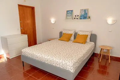 a bedroom with a bed with yellow pillows at Cozy Albufeira Charm in Albufeira