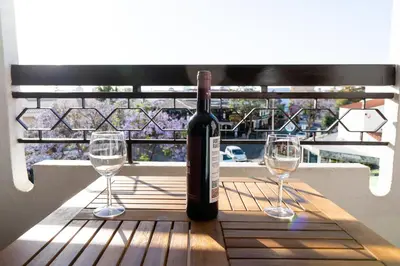 a bottle of wine sitting on a table with two glasses at Cozy Albufeira Charm in Albufeira