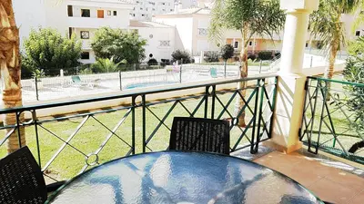 a balcony with two chairs and a view of a park at São Vicente By Albufeira Rental in Albufeira