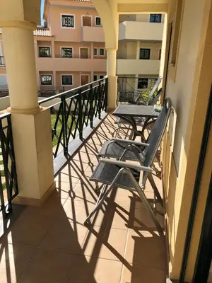 a balcony with a table and a chair on a building at São Vicente By Albufeira Rental in Albufeira
