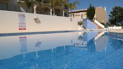 a swimming pool with blue water in a building at São Vicente By Albufeira Rental in Albufeira