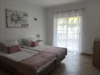a bedroom with a bed and a large window at São Vicente By Albufeira Rental in Albufeira