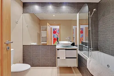 a bathroom with a sink and a tub and a toilet at News Apartment in Vilamoura