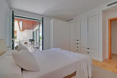 a white bedroom with a bed and a window at News Apartment in Vilamoura