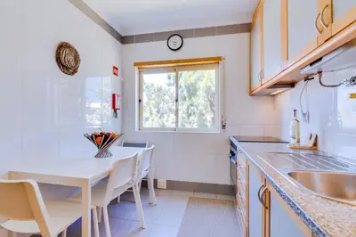 a kitchen with a white table and a window at AL - Apartamento Falésia Flat in Vilamoura