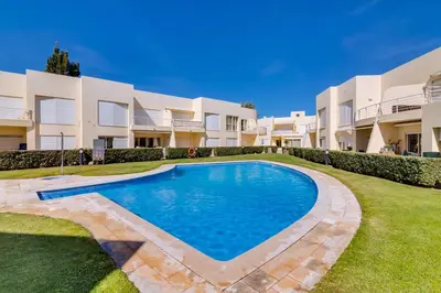 a villa with a swimming pool in front of a building at AL - Apartamento Falésia Flat in Vilamoura