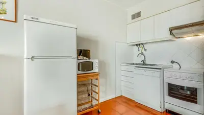 a kitchen with a white refrigerator and a microwave at Vilamoura Coastal Retreat by LovelyStay in Vilamoura