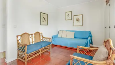a living room with a blue couch and chairs at Vilamoura Coastal Retreat by LovelyStay in Vilamoura