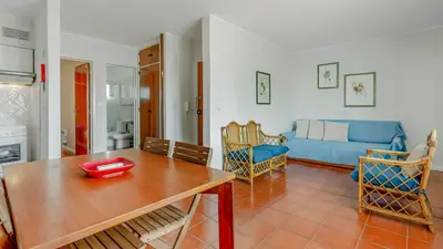 a living room with a table and a couch at Vilamoura Coastal Retreat by LovelyStay in Vilamoura