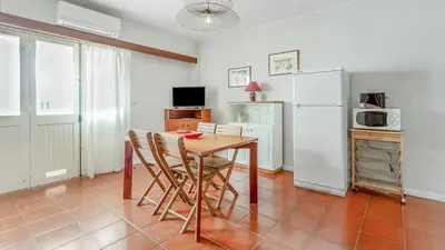 a kitchen with a table and chairs and a refrigerator at Vilamoura Coastal Retreat by LovelyStay in Vilamoura