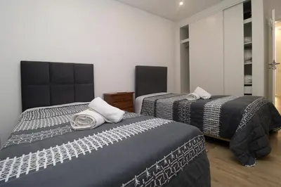 a bedroom with two beds and a mirror at Monica in Quarteira