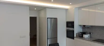 a kitchen with white cabinets and a stainless steel refrigerator at Monica in Quarteira