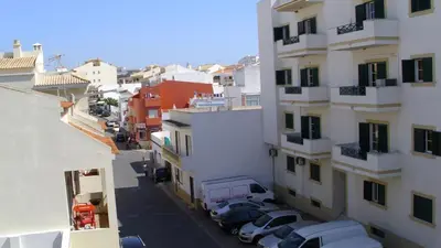 a view of a city street with cars parked next to buildings at Monica in Quarteira