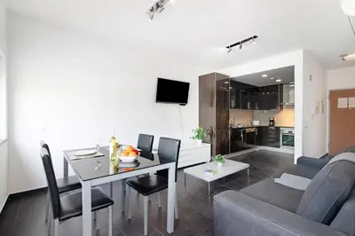 a living room with a table and a dining room at Apartamento Oceano in Albufeira