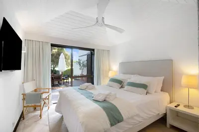a bedroom with a large white bed with a balcony at Vilamoura com Piscina e Wifi in Vilamoura
