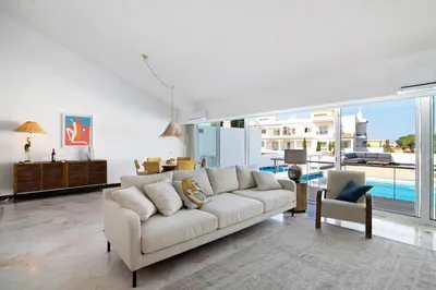 a living room with a white couch and a large window at Vilamoura com Piscina e Wifi in Vilamoura