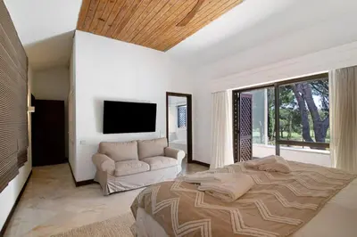 a bedroom with a large bed and a couch at Vilamoura com Piscina e Wifi in Vilamoura