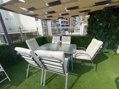 a table and chairs on a patio with grass at Sunny, The House - AL in Faro
