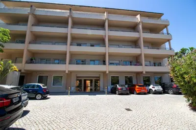 a large building with cars parked in a parking lot at Barracuda A14 in Albufeira