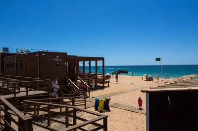 a beach with a building and people on the beach at Barracuda A14 in Albufeira