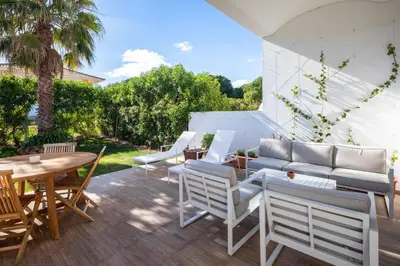 a patio with chairs and a table and a couch at Casa Relax à Olhos Albufeira in Albufeira