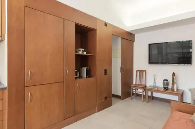 a living room with wooden cabinets and a tv at Alvaflor 102 - Vilamoura by HD Properties in Vilamoura