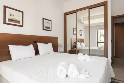 a bedroom with a white bed with towels on it at Alvaflor 102 - Vilamoura by HD Properties in Vilamoura
