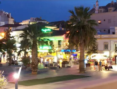 a group of palm trees in a city at night at Albufeira Old Town Center - VERASOL 1 in Albufeira