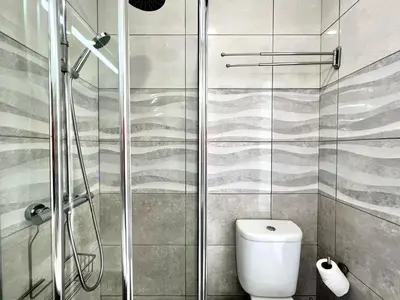 a bathroom with a toilet and a glass shower at Quarteira Ocean Breeze 1 With Pool by Homing in Quarteira