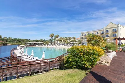 a pool with chaise lounges and chairs next to a building at Vilamoura Marina Lake in Vilamoura