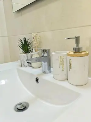 a bathroom sink with a faucet and some plants on it at Marina Holiday House in Quarteira