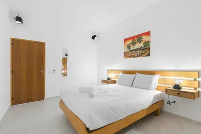 a bedroom with a bed with white sheets and a wooden headboard at Pool side Villa Zara in Albufeira