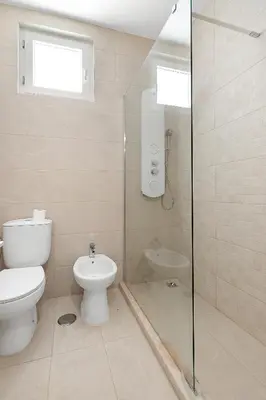 a bathroom with a toilet and a glass shower at Pool side Villa Zara in Albufeira