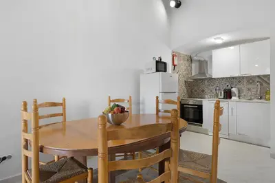 a kitchen with a wooden table and chairs in a room at Pool side Villa Zara in Albufeira