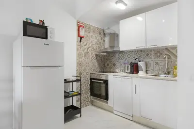 a kitchen with white cabinets and a refrigerator at Pool side Villa Zara in Albufeira