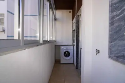 a laundry room with a washing machine in a hallway at Apartamento T3 in Faro