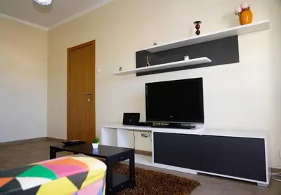 a living room with a flat screen tv on a wall at Apartamento T3 in Faro