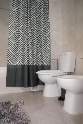 a bathroom with a toilet and a shower curtain at Apartamento T3 in Faro