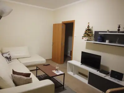 a living room with a white couch and a christmas tree at Apartamento T3 in Faro