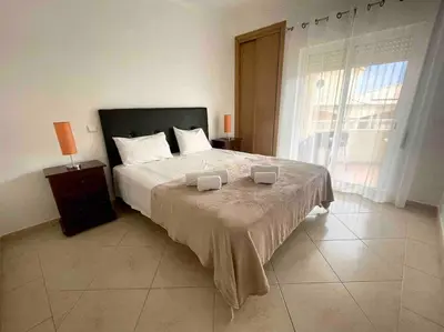 a bedroom with a large bed and a large window at Vilamoura-Praia da Falésia T2 in Quarteira